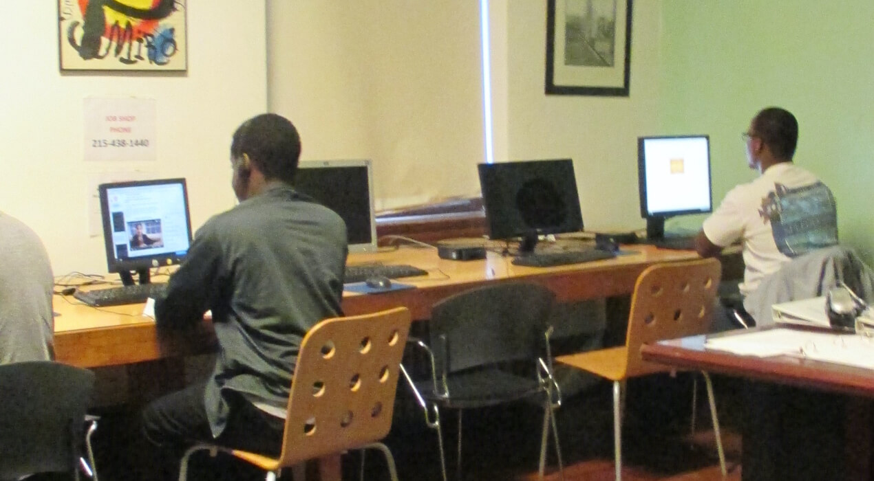 Men sitting at a computer desk
