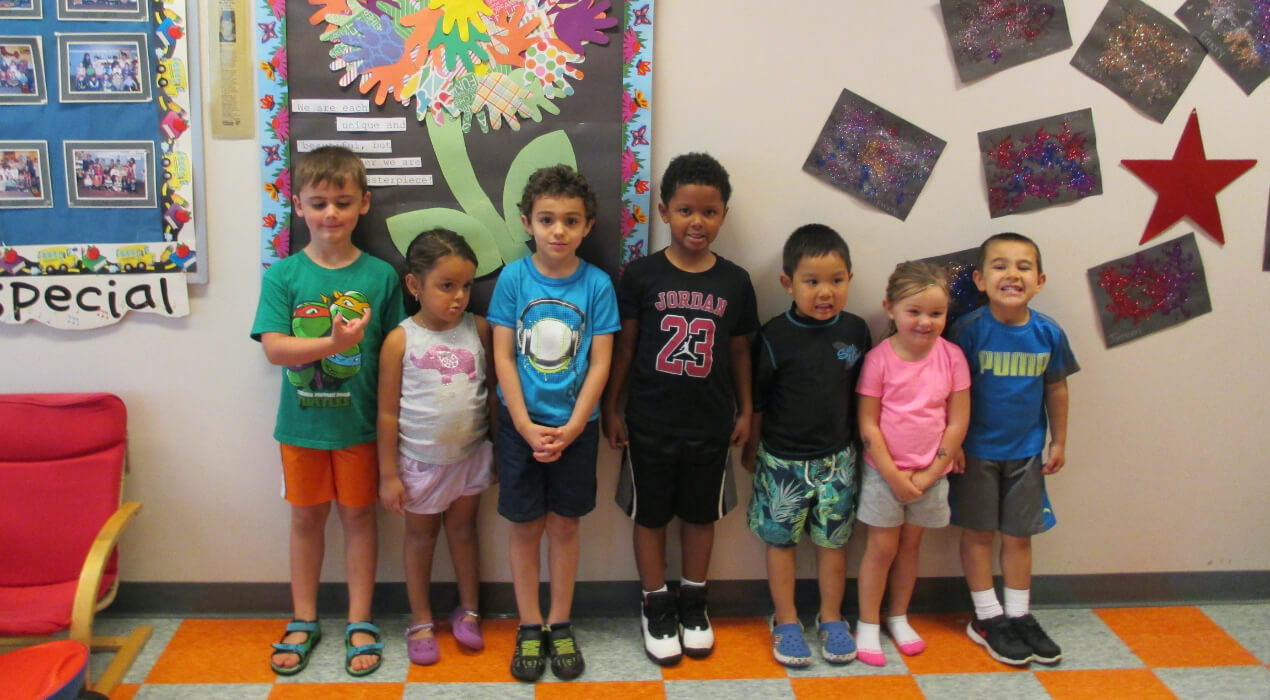 Small children in school smiling in a row