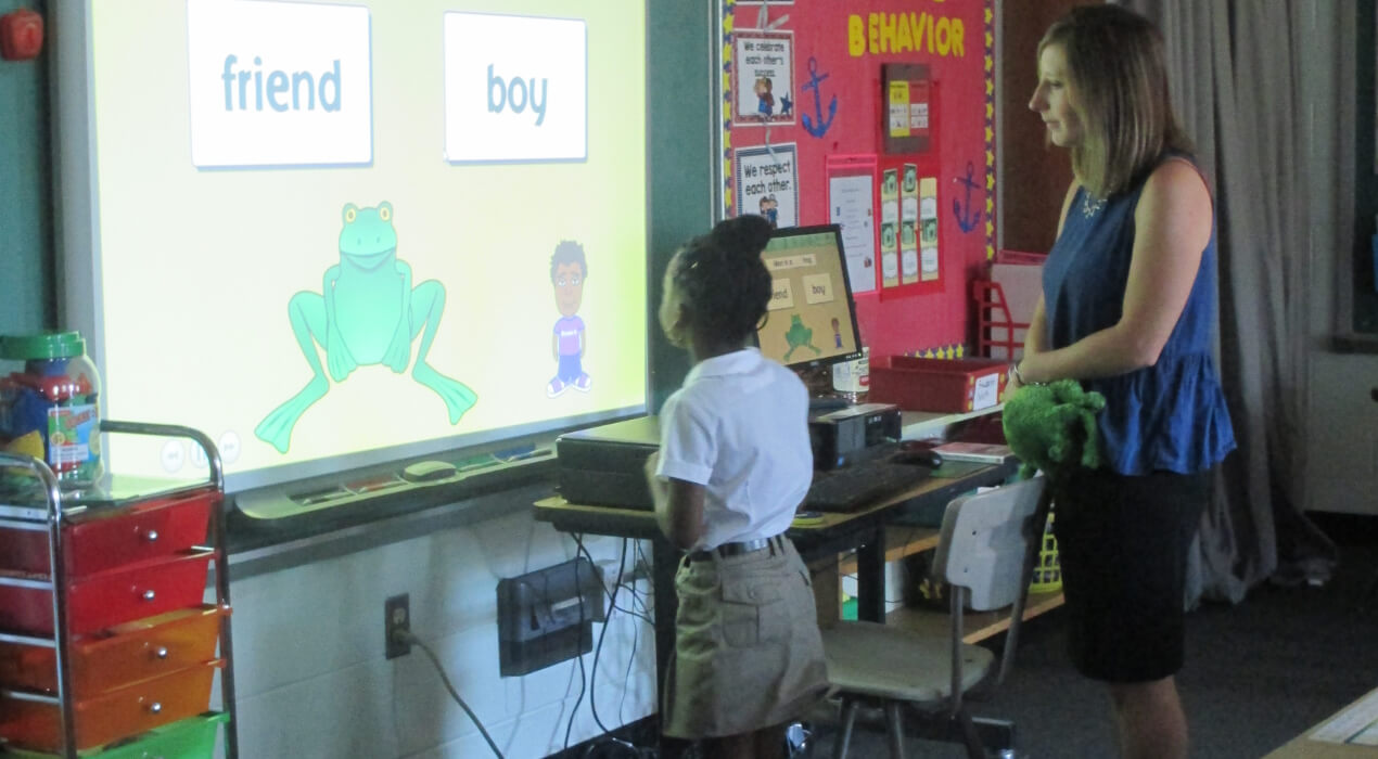 Teacher and student looking at a projector during class
